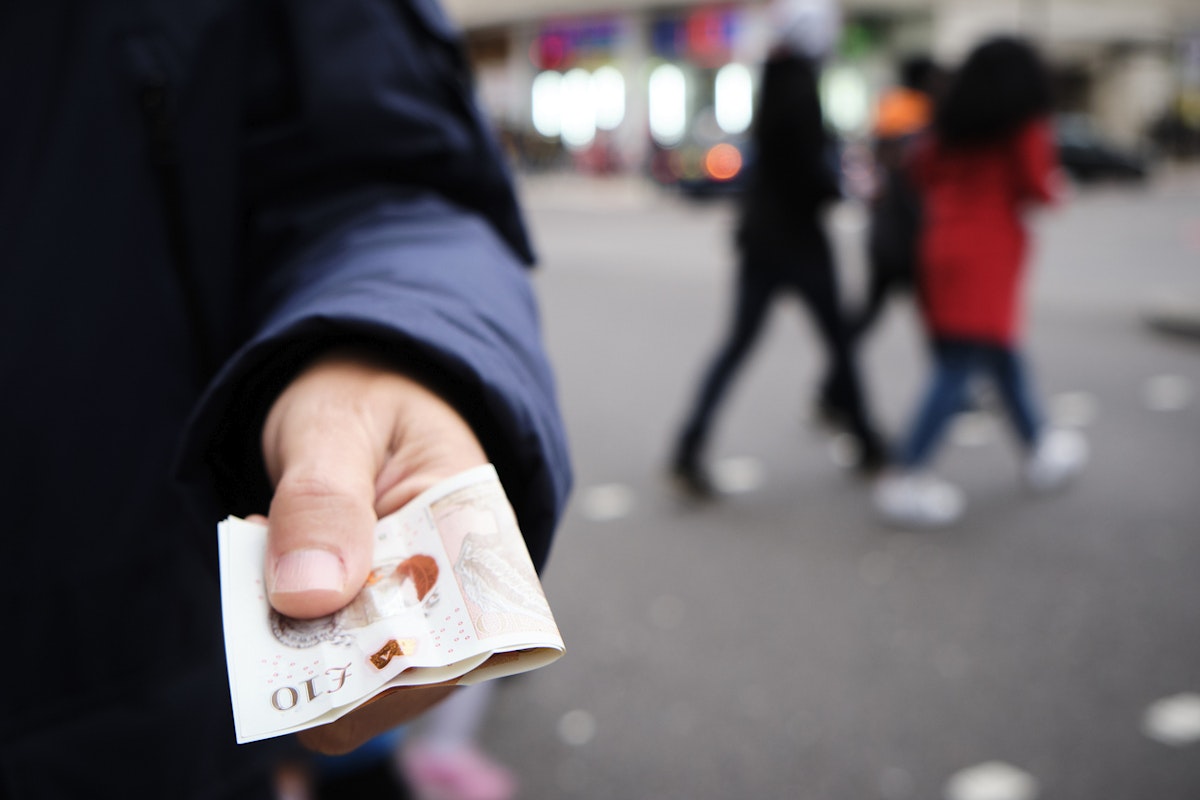 Man holding two £10 notes
